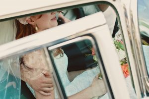 Close up photo of a bride and groom in a vintage vehicle