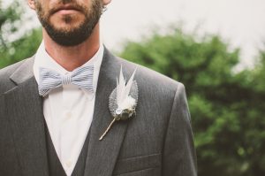 Photo of groom, closeup on flower in buttonhole